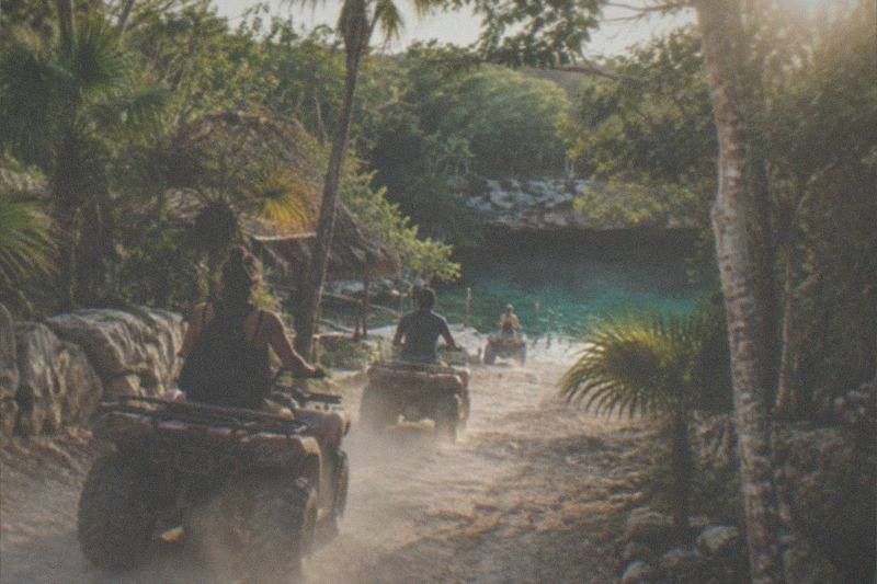 ATV riders on a jungle trail toward a Tulum cenote swim stop