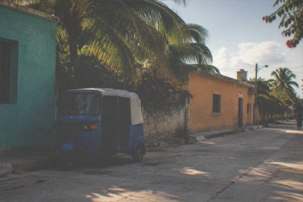 Quiet street corner with low colorful buildings, bikes leaning on a wall and open sky